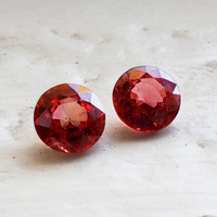 Bright pair of 5 mm round fiery orange red sapphires . This 5 millimeter round pair of poppy red orange sapphires are super lively.