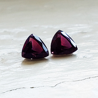 Pair of trillion burgundy wine sapphires. This unique pair of red wine color sapphires have a good triangle shape and have rich reddish undertones.  