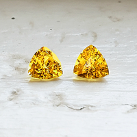 Matching pair of 4.5 mm trillion fancy yellow sapphires. This pair of 4.5 millimeter yellow sapphire trillions are clean and full of life. This would be a perfect triangle intense yellow sapphire pair as side stones for a ring or beautiful yellow sapphire