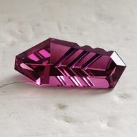 Fancy shape custom cut untreated rhodolite garnet.  This lively fantasy cut garnet is bright plum red in color and has nuances raspbery, pink and fushia.  